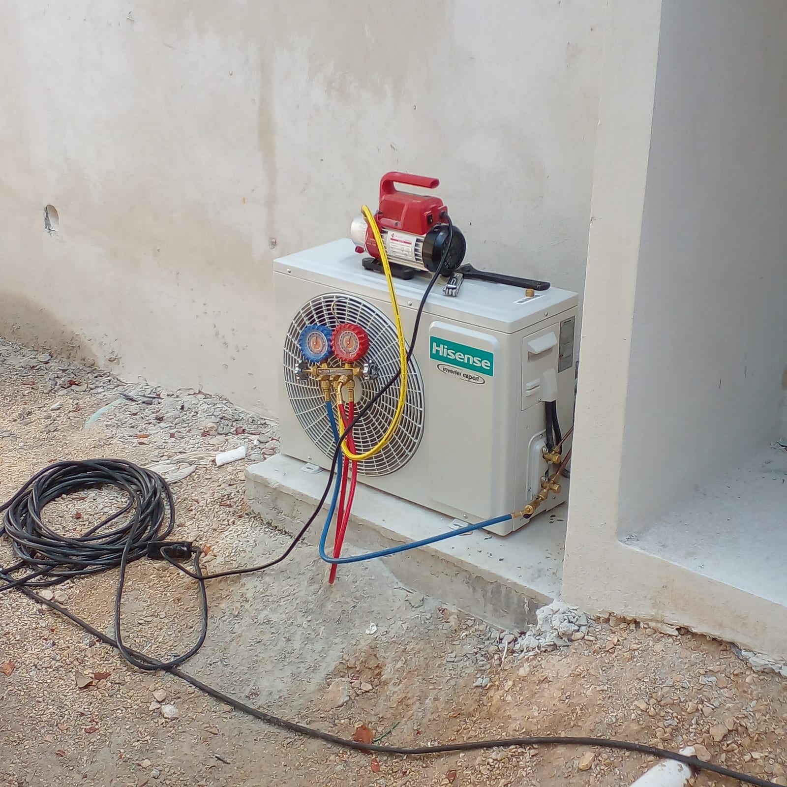 Unidad condensadora conectada con manómetros durante la carga de refrigerante, Cancún